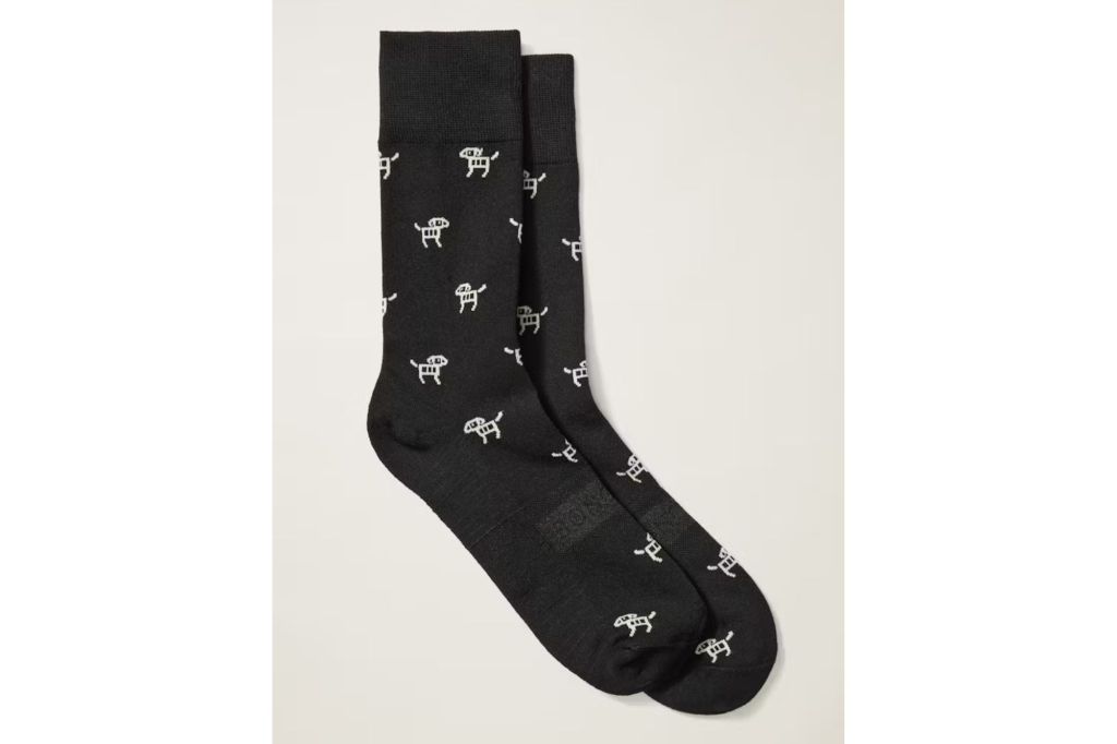 A pair of black dress socks with little white dogs on them.