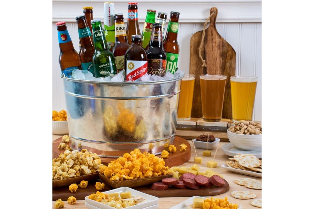 A bucket of beer surrounded by different snack food.