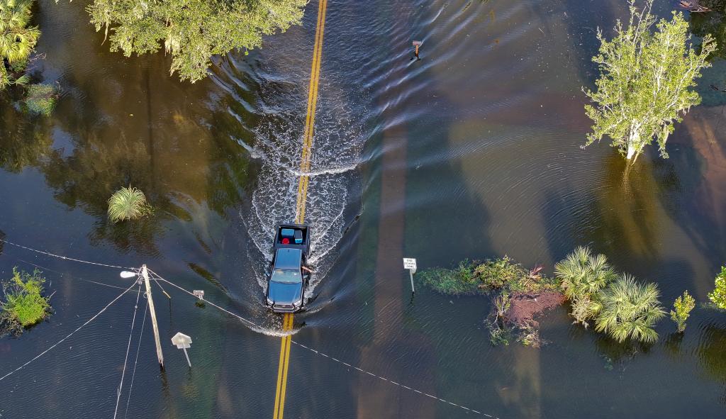 Aerial view of a car driving through flood waters in Crystal River, Florida after Hurricane Helene