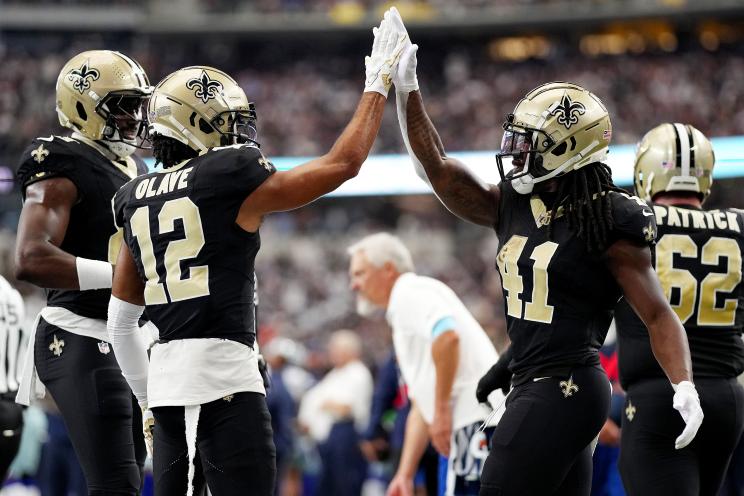 Alvin Kamara #41 and Chris Olave #12 of the New Orleans Saints celebrate a touchdown during the second quarter at AT&T Stadium on September 15, 2024 in Arlington, Texas.