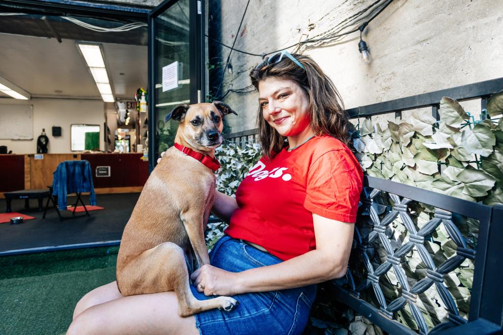 Annie Grossman sitting on a bench with her dog, Poppy, at School For the Dogs in the East Village, Manhattan