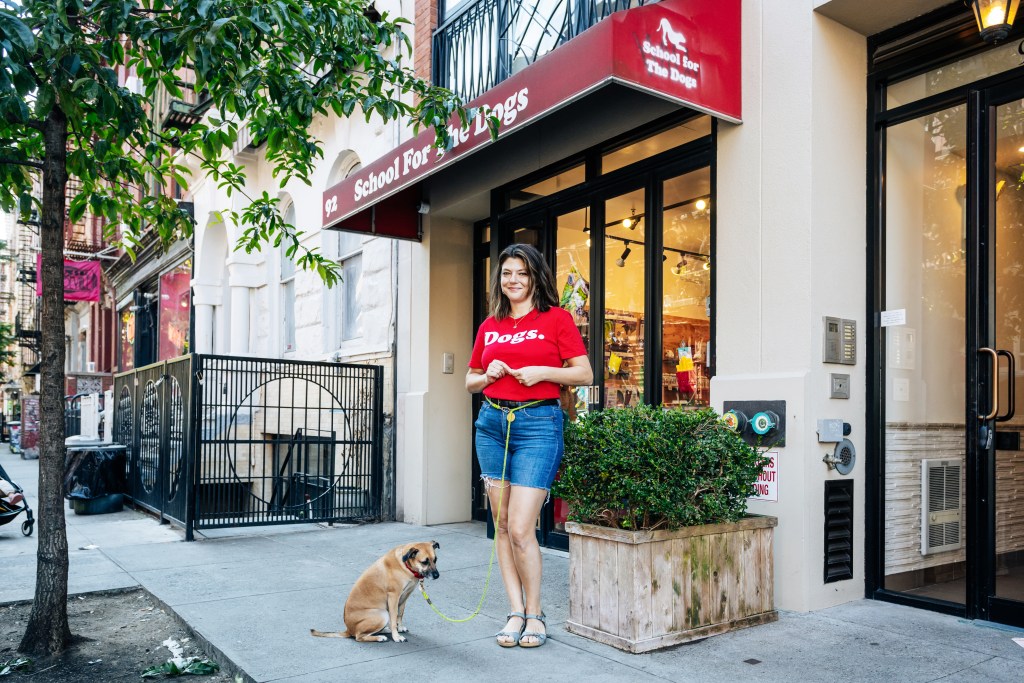 Annie Grossman standing with her leashed dog, Poppy, at School For the Dogs in the East Village, Manhattan