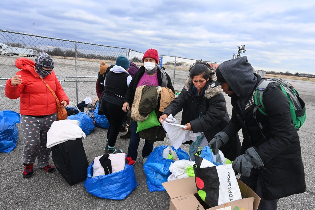 Migrants pick out clothes from a donation outside the Floyd Bennett Field migrant camp. 