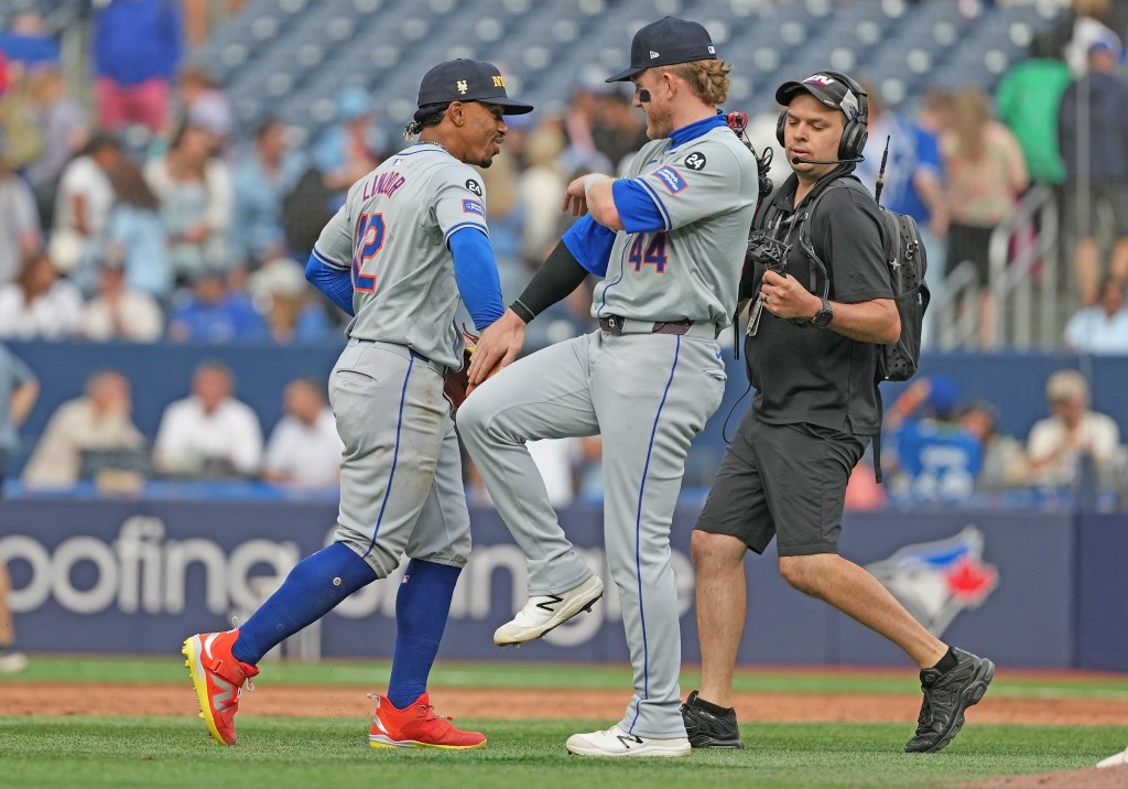 Mets shortstop Francisco Lindor (12) celebrates the win with center fielder Harrison Bader (44) against the Toronto Blue Jays at the end of the ninth  inning at Rogers Centre. 