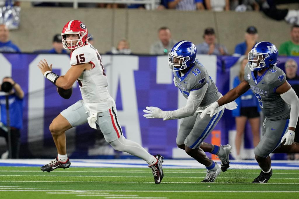 Georgia quarterback Carson Beck (15) is chased by Kentucky linebackers J.J. Weaver (13) and Jamon Dumas-Johnson (2) during the second half of an NCAA college football game, Saturday, Sept. 14, 2024, in Lexington, Ky. 