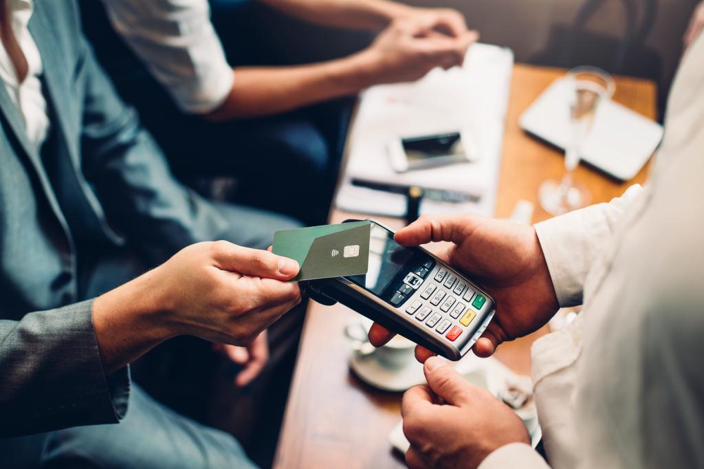 Close up of a card payment being made betweem a man and a waiter in a cafe.