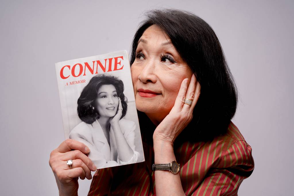 Connie Chung holding her new memoir about her life and career in journalism.