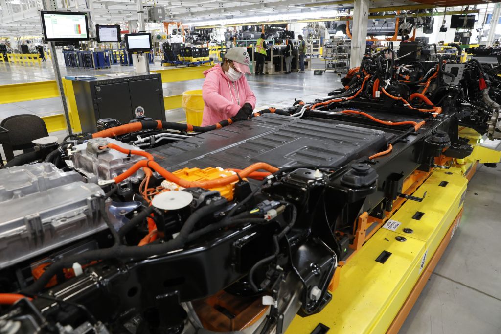 A woman works on the assembly line at an auto plant
