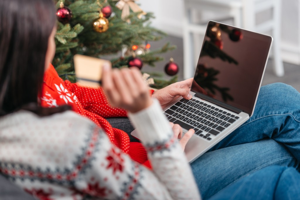 cropped shot of young couple shopping online with credit card and laptop at christmas.