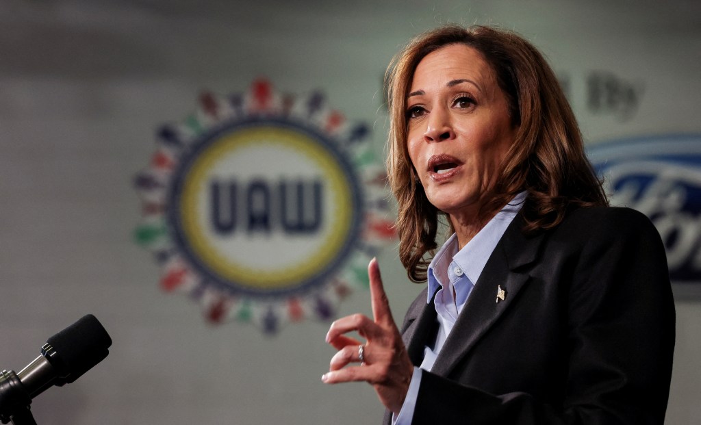 Democratic presidential nominee Kamala Harris speaking at a microphone during a campaign event at North Western High School in Detroit, Michigan