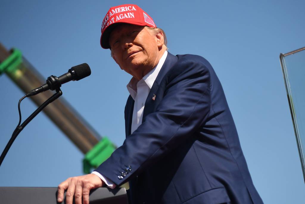 Donald Trump in a suit and red hat speaking to thousands of supporters at the Aero Center, Wilmington International Airport, September 21, 2024