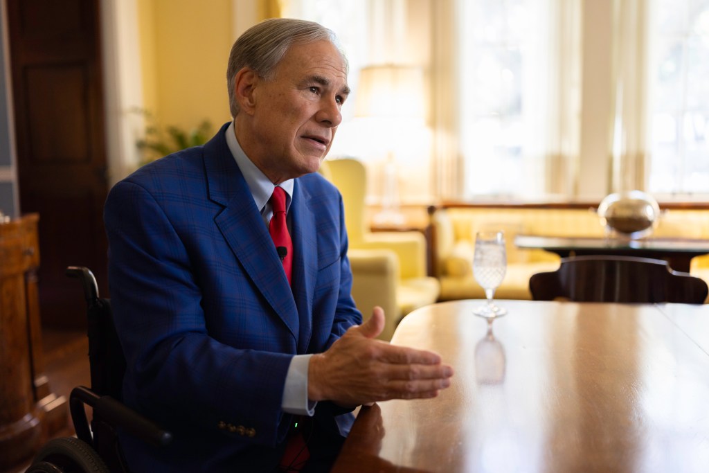 Texas Governor Greg Abbott in a suit, sitting at a table for an exclusive interview with the New York Post's Jennie Taer in Austin, Texas