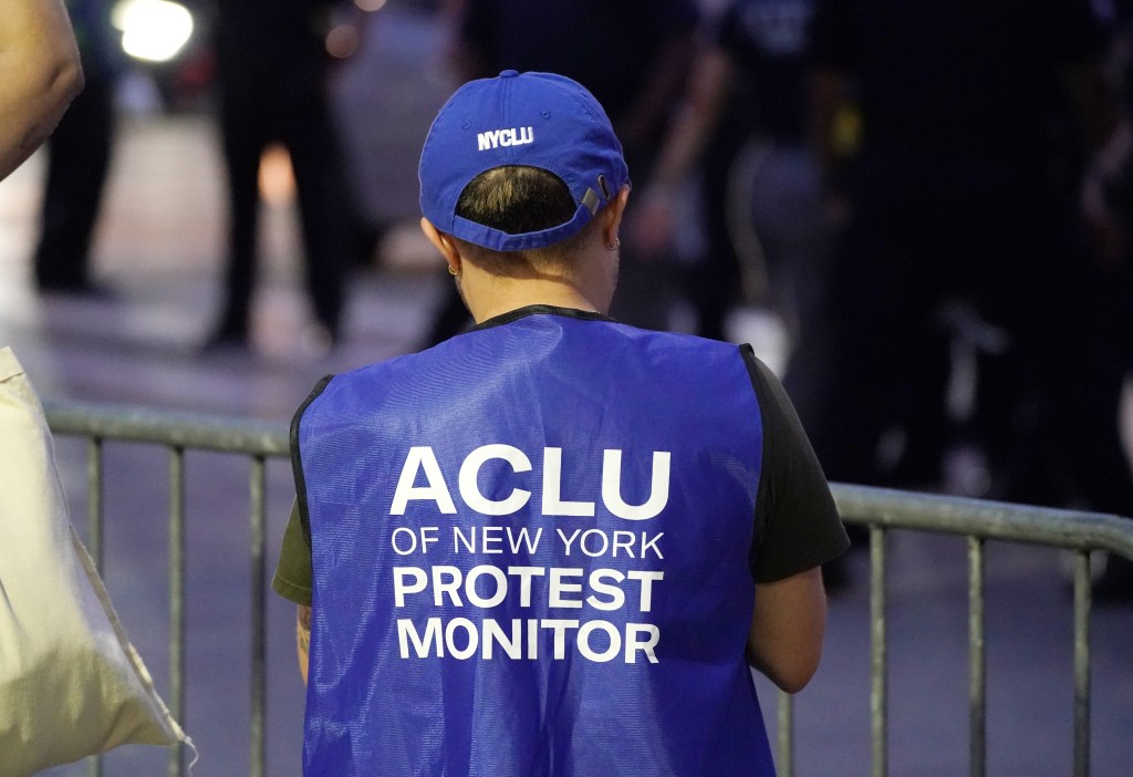 Person wearing an ACLU of New York protest monitor vest at a protest outside the New York City Police Foundation Gala at the Intrepid Museum