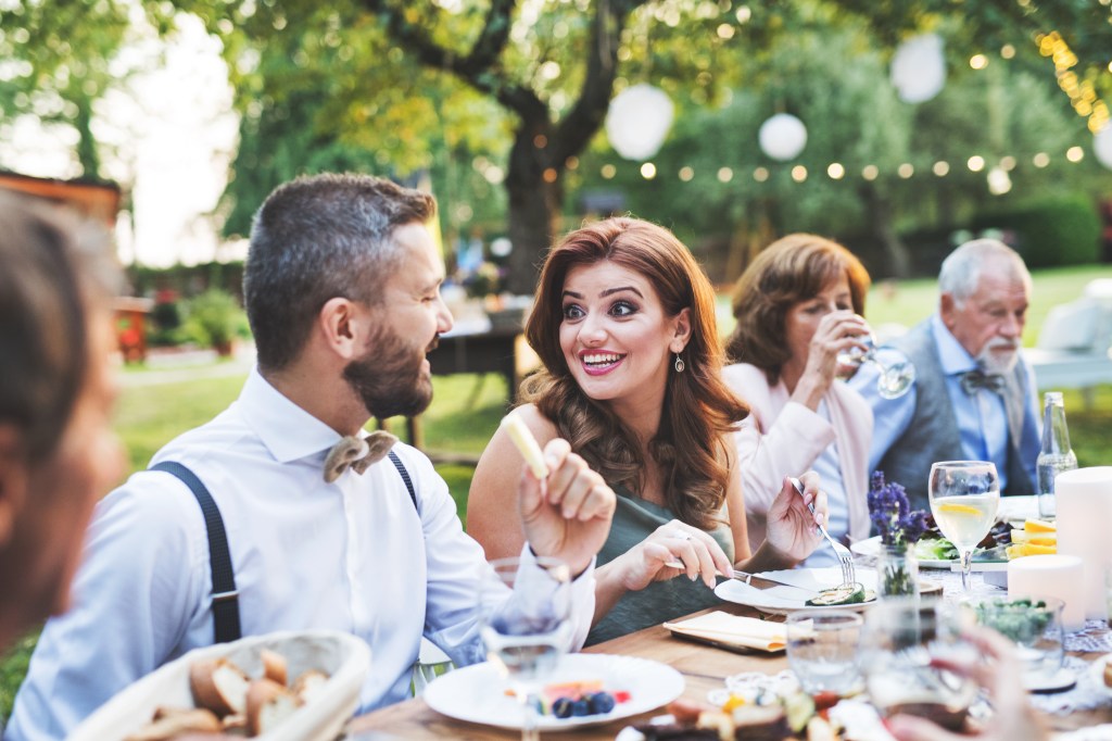 Guests sitting at the table and eating at the wedding.