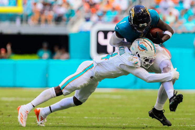 Jaguars running back Travis Etienne Jr. (1) runs with the football against Miami Dolphins cornerback Kader Kohou