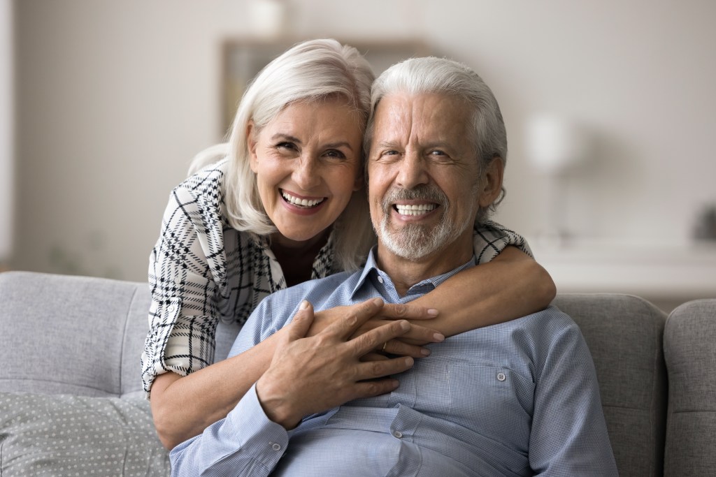 Cheerful mature 60s spouses posing for camera, home portrait. 