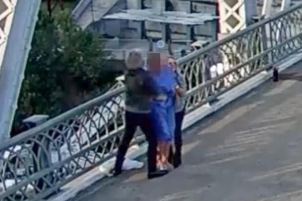 Jon Bon Jovi and a colleague consoling a person on the John Seigenthaler Pedestrian Bridge in downtown Nashville