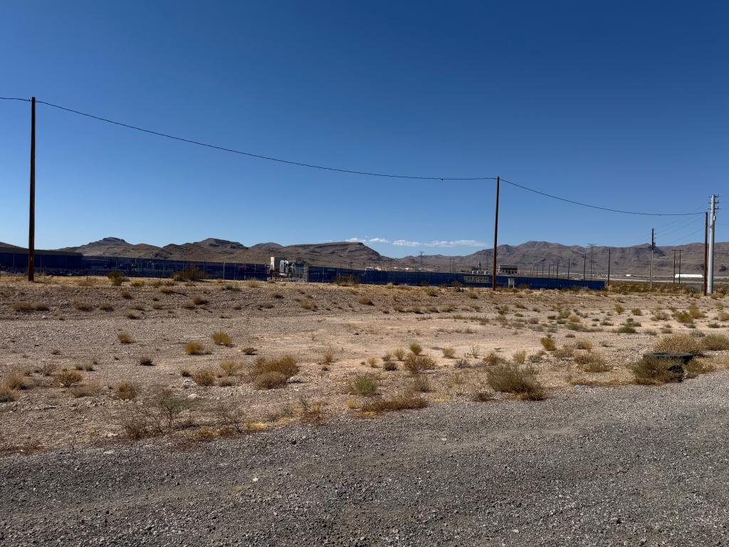 Empty lot in North Las Vegas, Nevada with power lines and mountains in the background, previously the location of a hoisted nude statue of Donald Trump