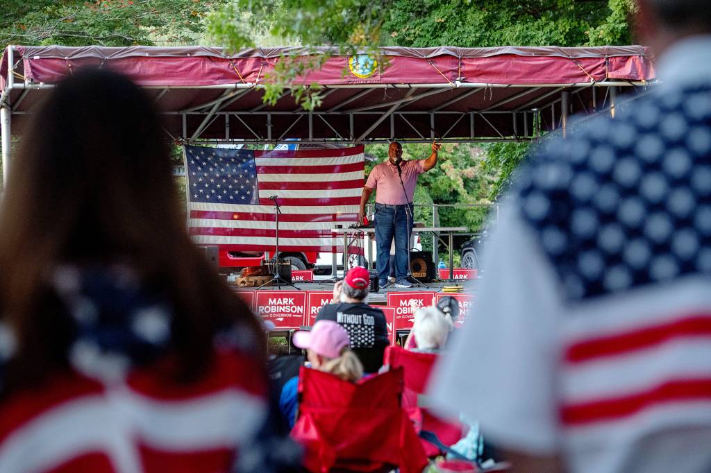 Mark Robinson, Republican candidate for North Carolina governor, standing on stage addressing a crowd at his rally in Burnsville