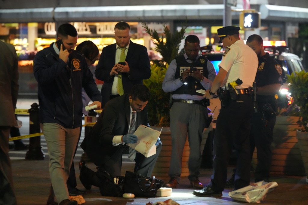 Members of the New York City Police Department examine the belongings of a victim at the scene of a fatal stabbing in the 46 St-Bliss St. subway station 