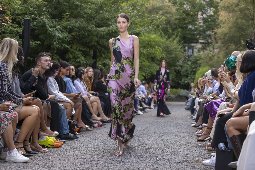 A model showcasing a Libertine design on a runway at New York Fashion Week, surrounded by an audience