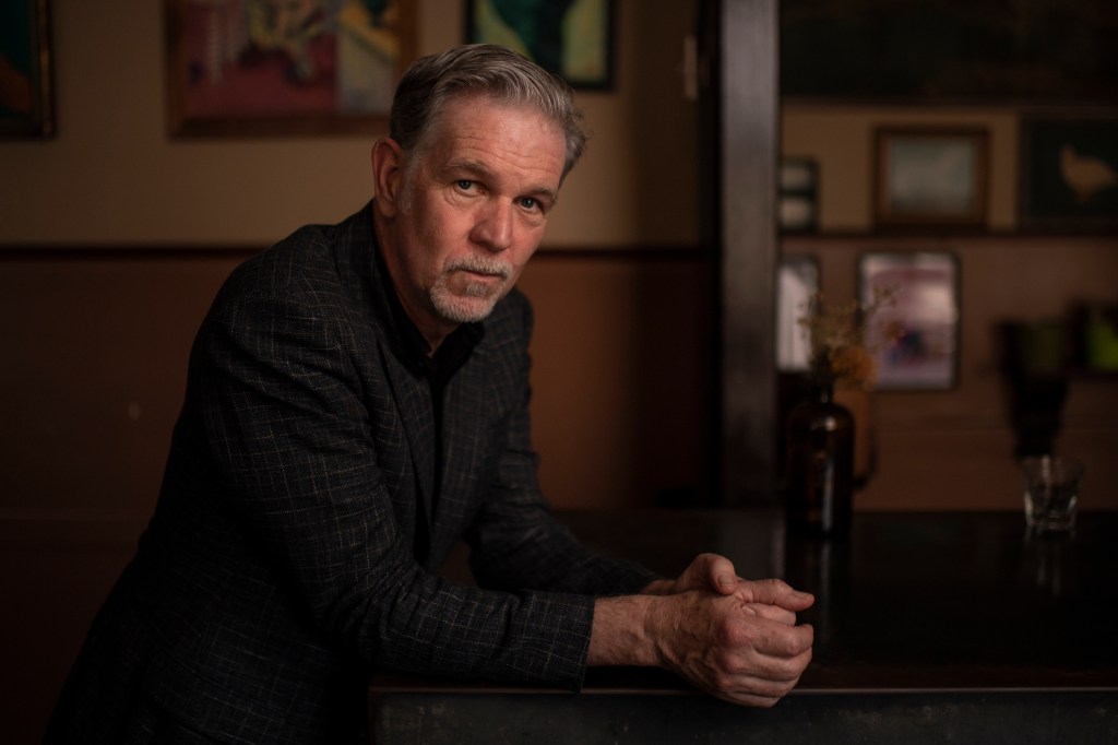 Netflix co-founder and CEO, Reed Hastings, sitting at a table during a meeting with subscription streaming executives in Sydney, 2022