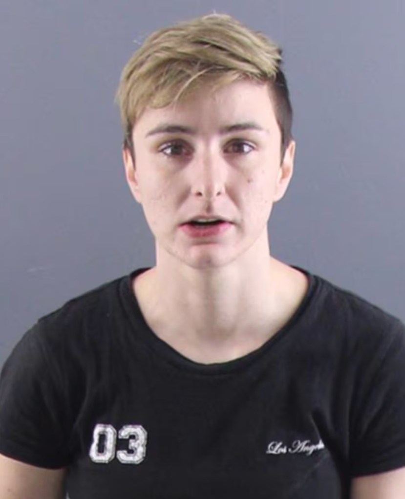 Mug shot of Andrea Luncsford. She has short blonde and brown hair and is wearing a black t-shirt. 