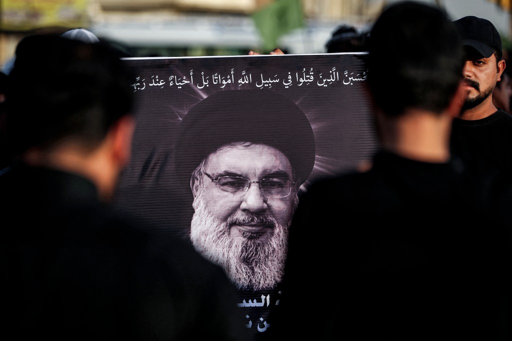 Mourners brandish a photo of Nasrallah at a memorial in Beirut on Sunday.