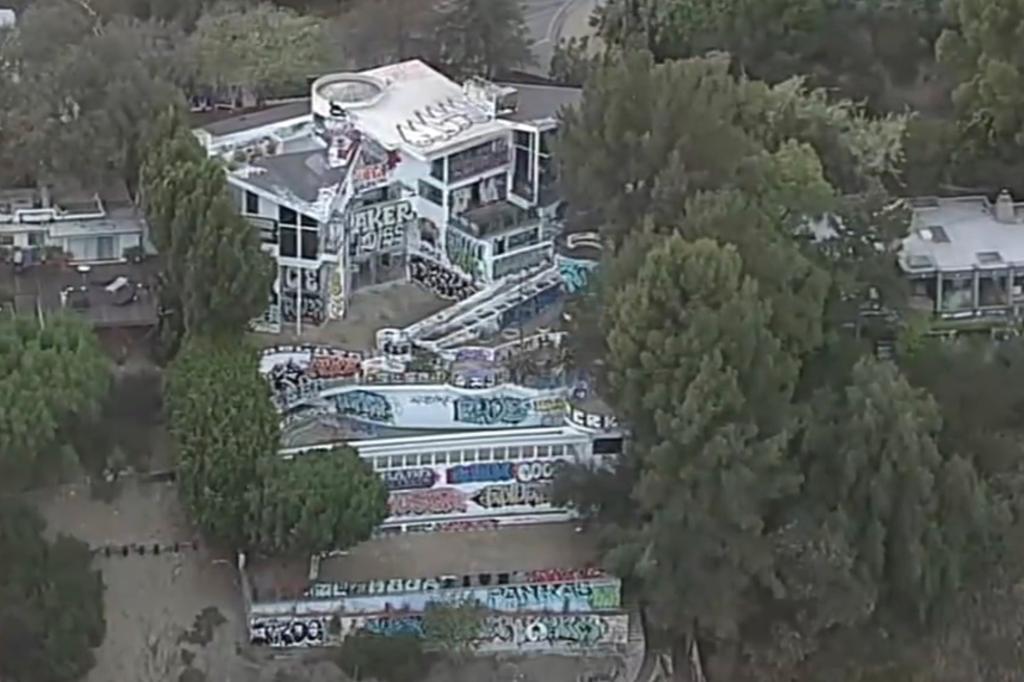 Squatters have taken over an abandoned Los Angeles mansion belonging to the son of the Philadelphia Phillies owner as neighbors view the high-end property as an eyesore and are scared for their safety.