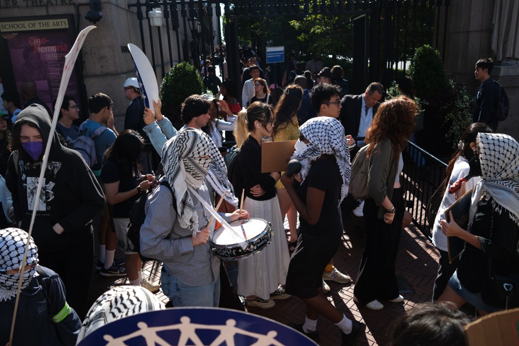 Rowdy demonstrators formed a picket line and banged drums as scores of students waited in lengthy lines to pass through security and gain access to Columbia's campus Tuesday. 