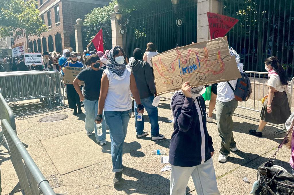 Pro-Palestine protestors demonstrating with signs as Columbia University students line up to enter campus on the first day of fall semester, 2024