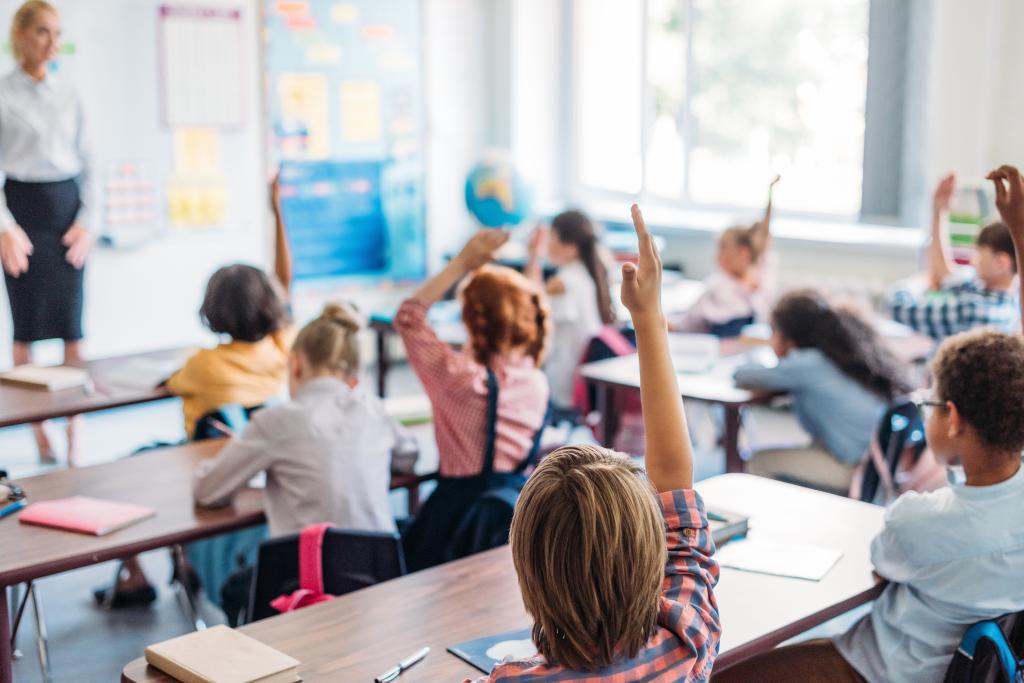 pupils raising hands on lesson to answer teacher question