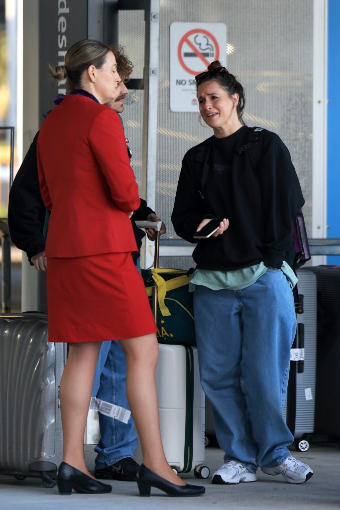 Australian Olympian Rachael 'Raygun' Gunn and husband Samuel Free arriving at Sydney International Airport, carrying luggage and Team Australia sports bag