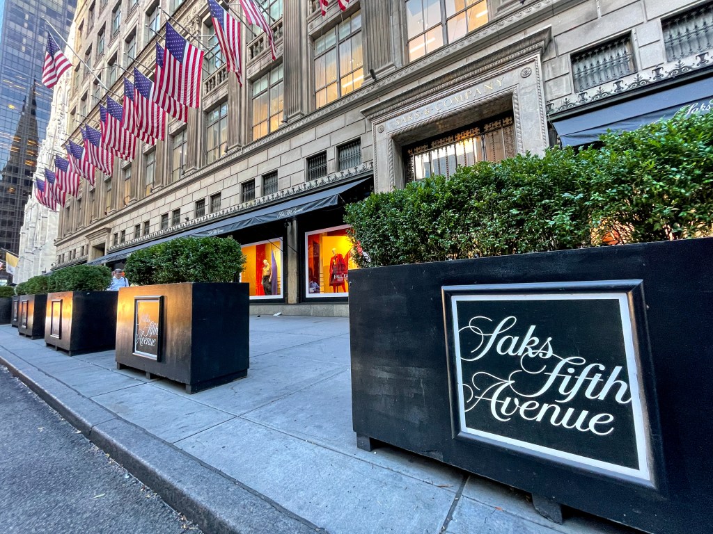 Saks Fifth Avenue department store building with flags on the side in midtown Manhattan.