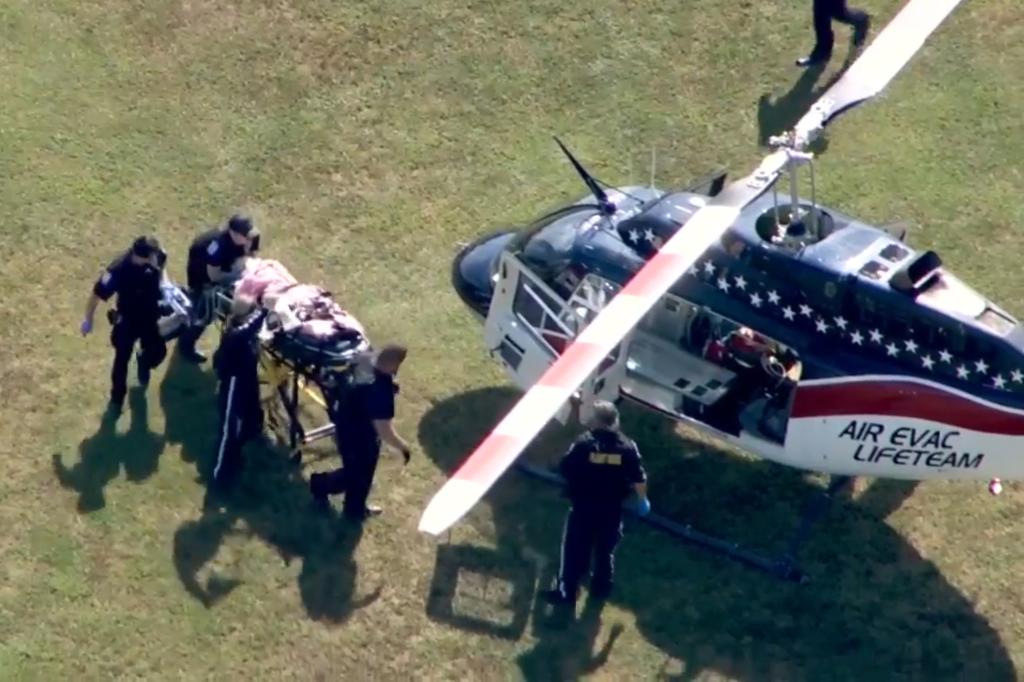 The scene outside Apalachee High School in Winder, Georgia, as a wounded individual is escorted by medical personnel onto a helicopter.