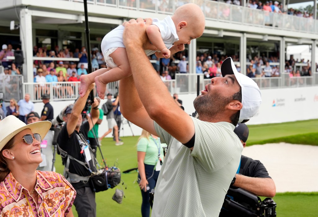 Scottie Scheffler celebrates with wife Meredith Scheffler hoisting their baby boy Bennett Scheffler in the air after putting out on the 18th green winning the TOUR Championship golf tournament.