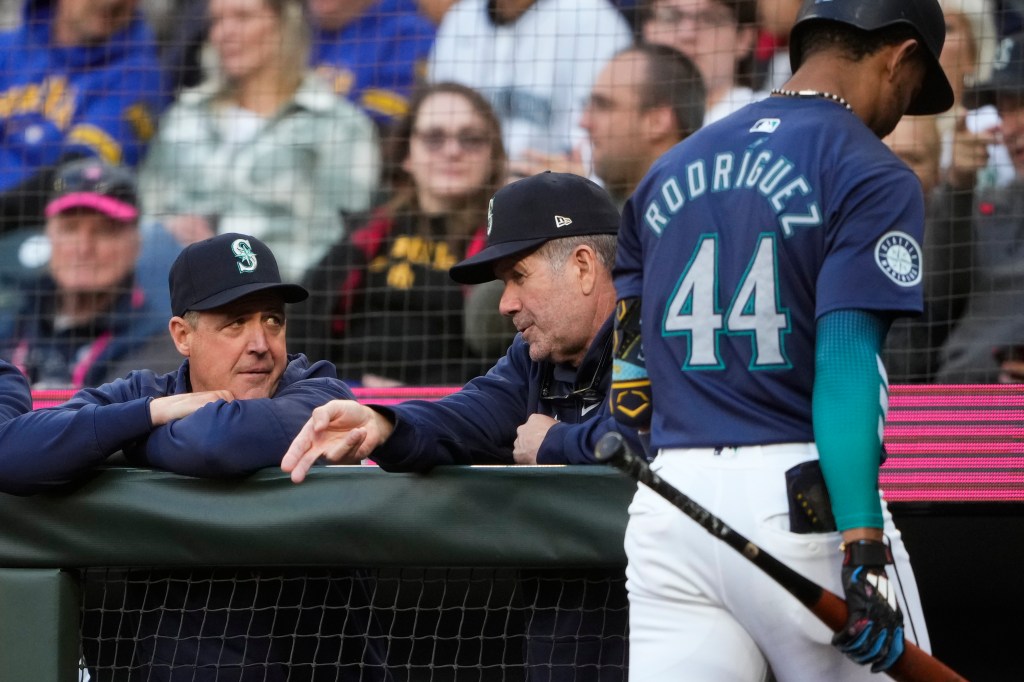 Seattle Mariners manager Dan Wilson, left, talks with hitting coach Edgar Martinez as Julio RodrÃguez (44) walks to the dugout after striking out against the Tampa Bay Rays during the first inning of a baseball game, Tuesday, Aug. 27, 2024.