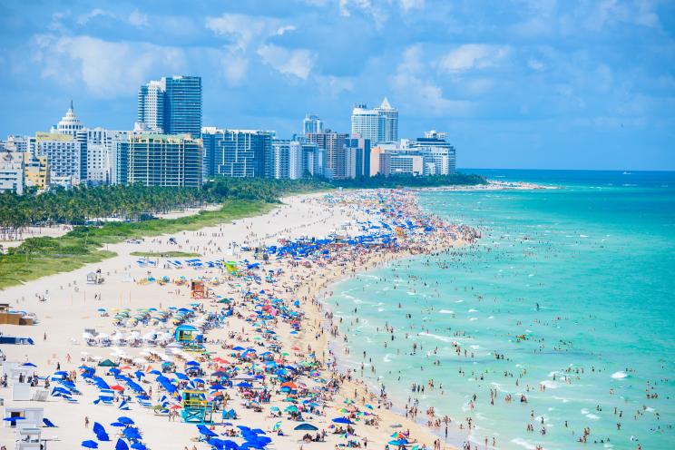 Aerial view of South Beach, Miami Beach showing a crowded beach with numerous buildings in the background