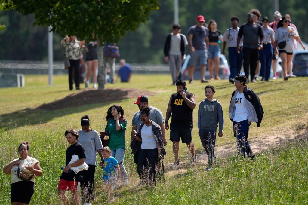 Students and parents walk off the school's campus after being reunited.