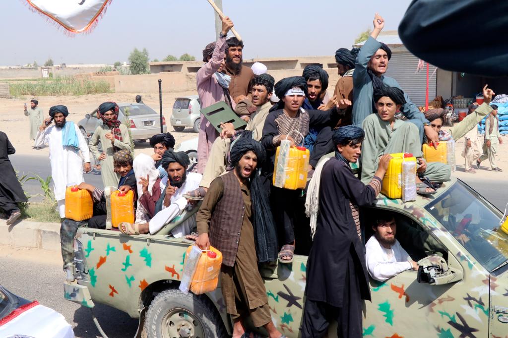 Taliban fighters carry dummy yellow canisters intended to represent homemade explosives, as they celebrate the third anniversary of the withdrawal of US-led troops from Afghanistan, in Lashkar Gah, Helmand province, southwestern Afghanistan, Wednesday, Aug. 14, 2024. 