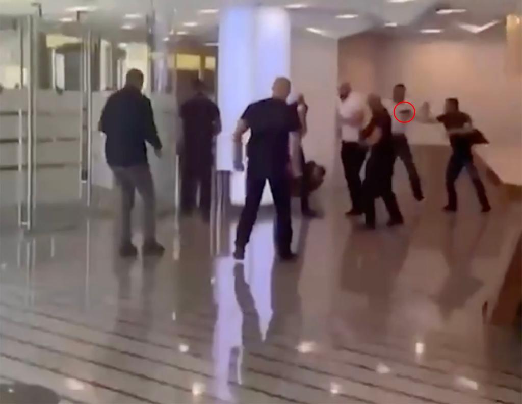 Chatoic scenese break out in the Moscow offices, where a man can be seen with a gun.