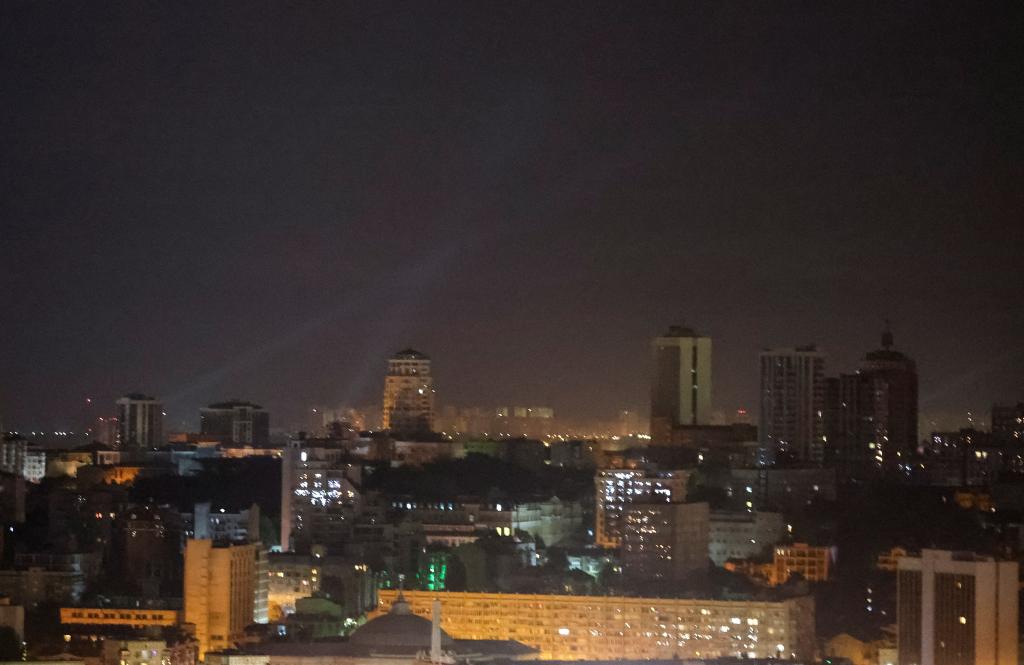 Ukrainian service personnel using searchlights to locate drones in the night sky over the city centre of Kyiv, Ukraine, during a Russian drone strike.