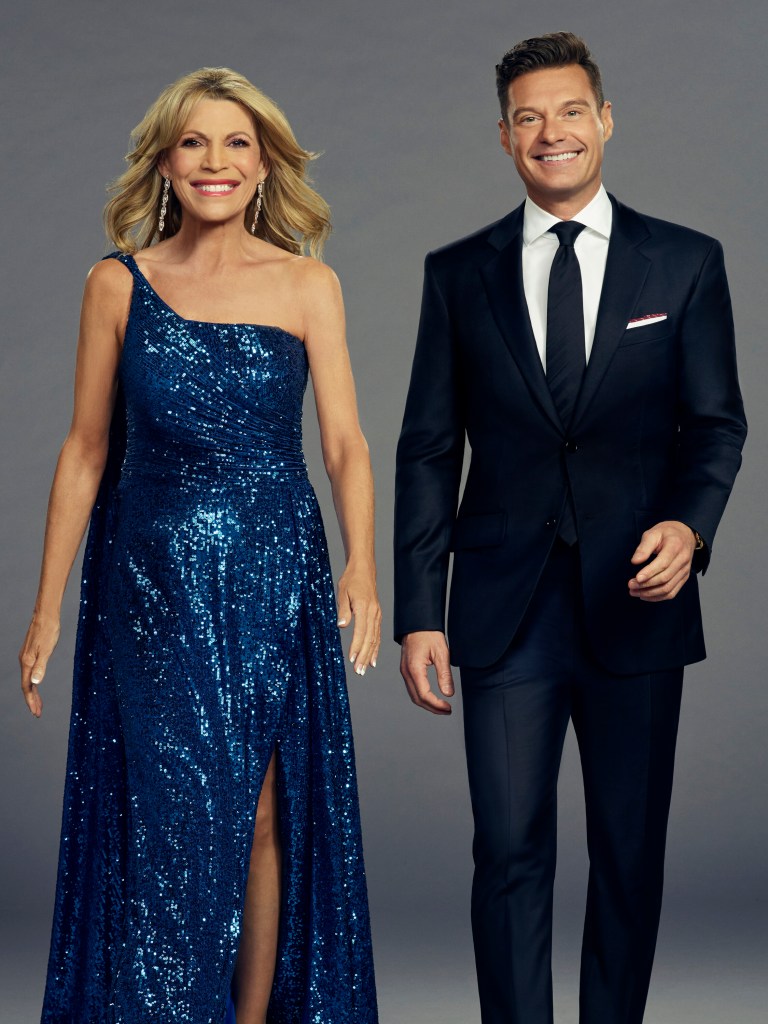 Vanna White in a blue dress and Ryan Seacrest hosting Wheel of Fortune