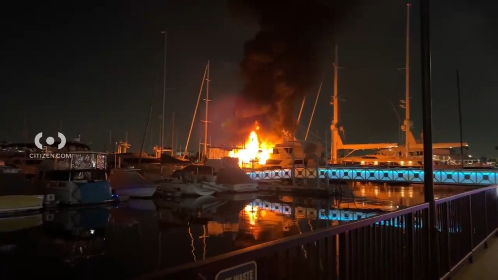 Witnesses captured the flames tearing through the 100-foot yacht as fireworks illuminated the black smoke and flew across the sky. 