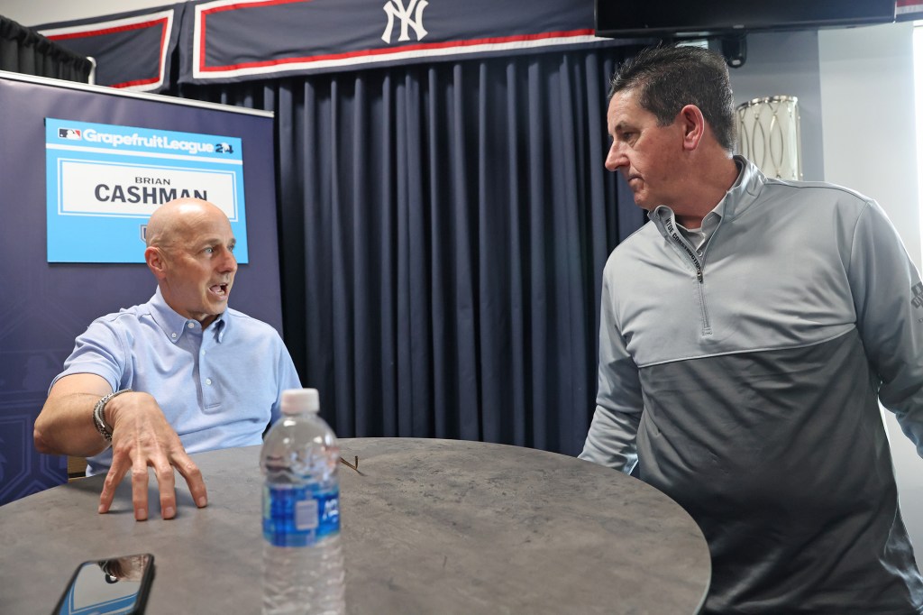 Brian Cashman (l.) talks with Phillies manager Rob Thomson during spring training media day.