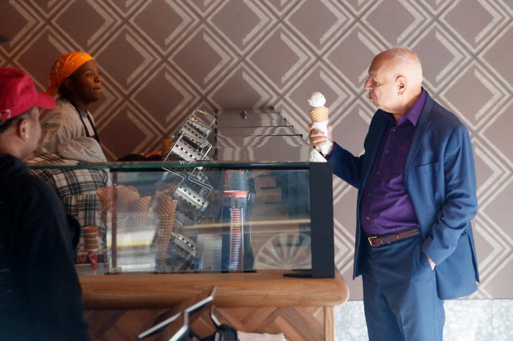 Steve Cuozzo stands at the counter holding an ice cream cone at Salt & Straw NYC. 