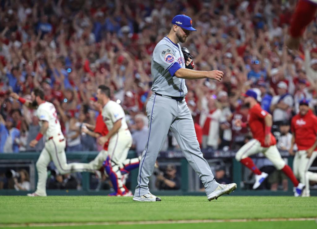 New York Mets pitcher Tylor Megill walks off the field as the Philadelphia Phillies celebrate after Philadelphia Phillies outfielder Nick Castellanos #8, won the game with an RBI single in the 9th inning.