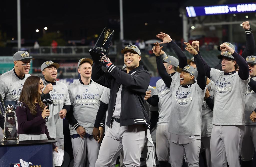 Giancarlo Stanton holding the ALCS MVP trophy after the Yankees beat the Guardians to advance to the World Series. 