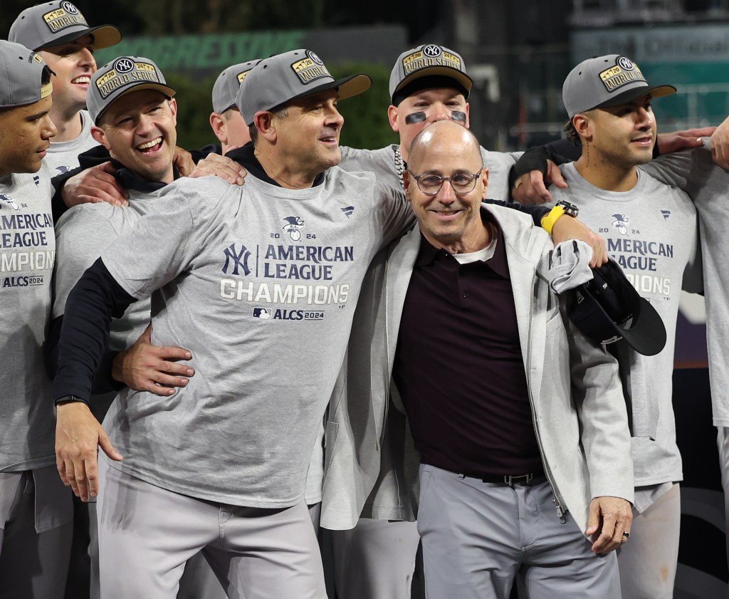 Yankees manager Aaron Boone with GM Brian Cashman on the podium during the ALCS Trophy presentation. 