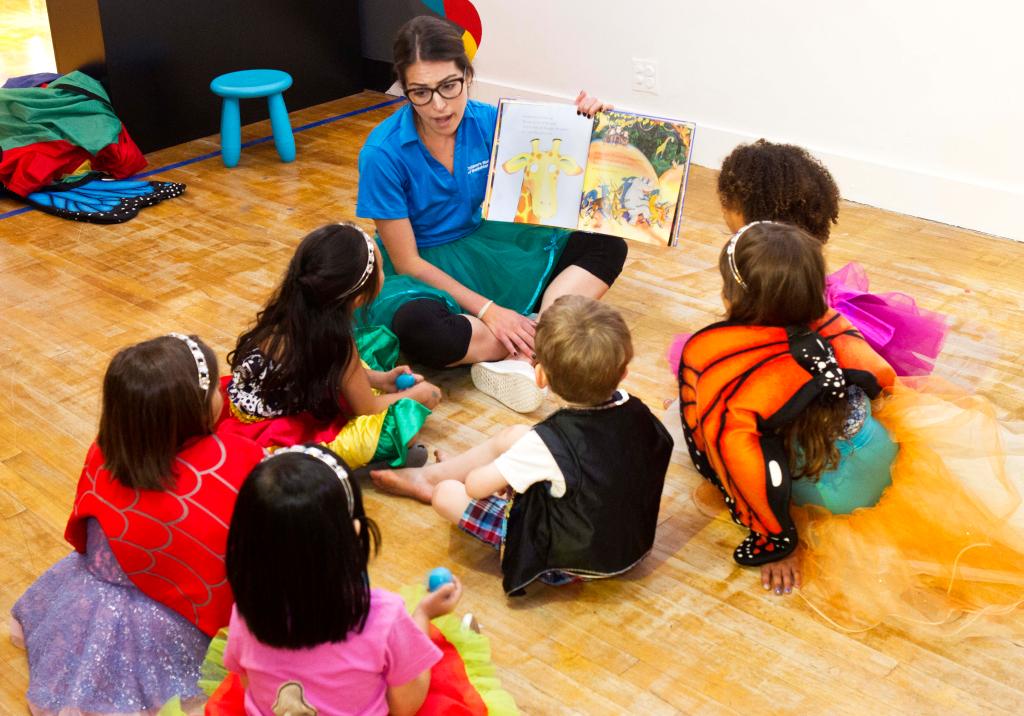 A museum worker reads to a group of children at the 83rd street museum location.